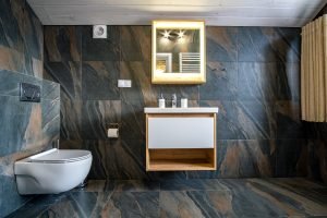 Interior of modern stylish bathroom with black tiled walls 2