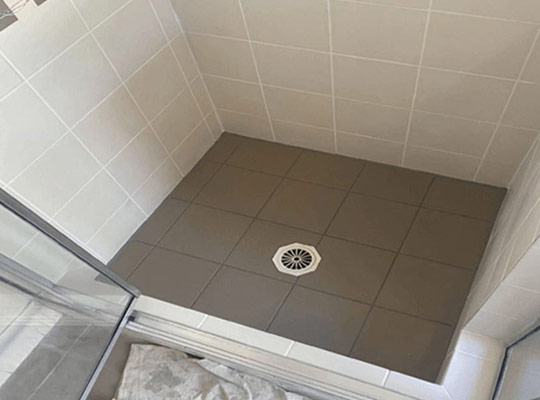 Regrouting is usually enough when tiles are intact and firmly bonded to the wall or floor.